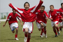 Children celebrate a goal during a youth soccer match in Tunis, April 2006. This summer's tournament is the fourth FIFA World Cup Tunisia qualified for. EPA/STR
