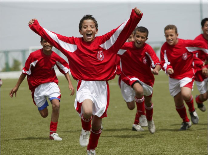 Children celebrate a goal during a youth soccer match in Tunis, April 2006. This summer's tournament is the fourth FIFA World Cup Tunisia qualified for. EPA/STR