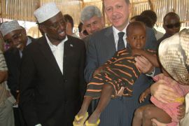 أوردوغان يحمل أحد أطفال النازحين في مخيم راجو لدى زيارته إلى مقديشو العام الماضي.