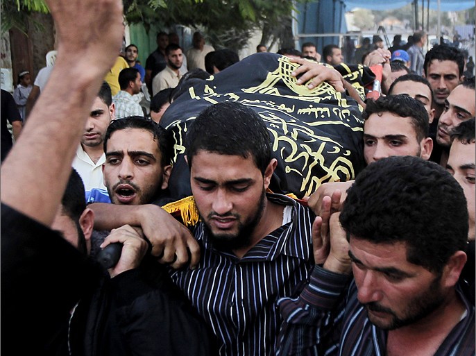Palestinians carry the body of Abdullah Maqawai during his funeral in Rafah in the southern Gaza Strip on October 8, 2012 after he died of his wounds sustained in an Israeli air strike. Gaza's ruling Hamas movement and the Islamic Jihad group fired a barrage of projectiles at Israel, a day after a targeted Israeli air strike on the Palestinian enclave. AFP PHOTO/SAID KHATIB