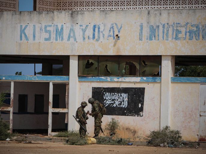 FA487 - KISMAYO, -, SOMALIA : This handout photograph released by the African Union-United Nations Information Support Team on October 2, 2012 shows shows soldiers of the Kenyan Contingent serving with the African Union Mission in Somalia (AMISOM) standing near the black flag of the Al Qaeda linked group Al Shabaab painted on the wall of Kismayo Airport.Blasts rocked the Somali port city of Kismayo on Tuesday as Kenyan troops from the African Union force and their allies entered the former Islamist bastion, the force, residents and the Shebab militia said. RESTRICTED TO EDITORIAL USE - MANDATORY CREDIT "AFP PHOTO / AU-UN IST PHOTO / STUART PRICE" - NO MARKETING NO ADVERTISING CAMPAIGNS - DISTRIBUTED AS A SERVICE TO CLIENT- AU-UN IST PHOTO / STUART PRICE.