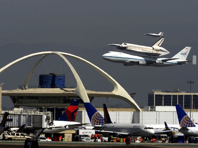 The Space Shuttle Endeavour mounted on a 747 airliner flies over the Theme Building at Los Angeles Airport in Los Angeles, California, USA , 21 September 2012 completing a three day cross-country farewell tour that began 19 September 2012 at NASA’s Kennedy Space Center in Florida.On 21 September 2012, the shuttle flew from Edwards Air Force Base, to Sacramento and the Bay Area and then toured southern California before touching down at Los Angeles International Airport. Next month Endeavour will move to the California Science Center in Los Angeles, where it will be put on permenant display. EPA/MICHAEL NELSON