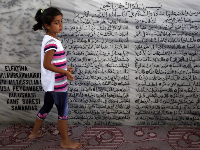 A girl stands in a tomb, a holy site for the Alawite community, in the Samandag district of Hatay province