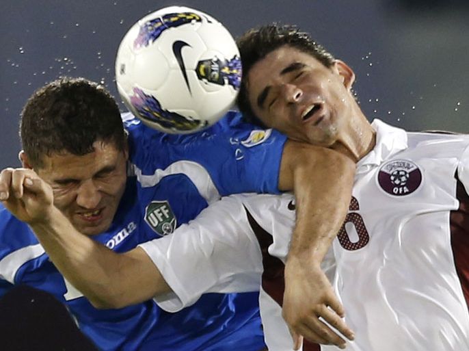 Qatar's Marcone Amaral (R) fights for the ball with Uzbekistan's Ulugbek Bakaev during their 2014 World Cup qualifying soccer match in Doha, October 16, 2012. REUTERS/Fadi Al-Assaad (QATAR - Tags: SPORT SOCCER)