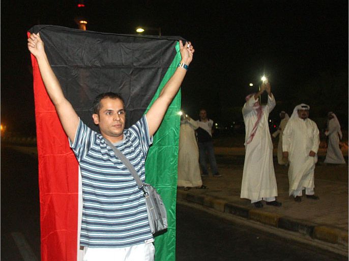 A Kuwaiti opposition supporter holds up the flag during a protest in Kuwait City, on October 21, 2012, against the decision by Emir Sheikh Sabah al-Ahmad al-Sabah to amend the electoral law despite it having been confirmed by a court last month. Kuwaiti riot police beat opposition protesters who were gathering for a massive demonstration against a decision to change the electoral law, organisers and witnesses said. AFP PHOTO/YASSER AL-ZAYYAT