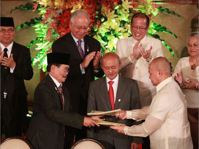 epa03433747 (L-R, 2nd Row) Moro Islamic Liberation Front (MILF) Chief Al Haj Murad, Malaysian prime minister Najib Razak, Philippine President Benigno Aquino III and Teresita Quintos-Deles,adviser on the peace process witness the exchange of documents after signing of a framework agreement between the Philippines government and Muslim separatist rebels inside the Malacanang presidential palace, Manila, Philippines, 15 October 2012. The Philippine government and the largest Muslim rebel group signed a preliminary peace pact aimed at ending a 43-year rebellion in the country's troubled south. The framework agreement calls for the establishment of a new autonomous region to be called Bangsamoro, or Muslim nation, in the southern region of Mindanao, by 2016. Also in photo are (L-R, First Row) Mohagher Iqbal, Chairperson for the MILF panel; Tengku Abdul Ghafar, Malaysian facilitator to the peace deal and Dean Marvic Leonen, Chaiperson for Government of the Philippines panel.The 12,000-strong MILF had been fighting the Philippine government since 1978 when it split from the Moro National Liberation Front, which opted for autonomy and signed a peace agreement in 1996. The MILF entered into peace talks with the government in 1997 and first agreed to accept autonomy in an unsuccessful round of negotiations in 2008. EPA/DENNIS M. SABANGAN