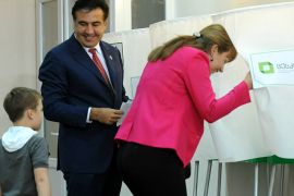 afp : Georgia's President Mikheil Saakashvili (C) looks at his ans son Nikoloz (L) while his wife, Sandra Roelofs (R), enters the voting booth at a polling station Tbilisi, on October 1, 2012. Saakashvili said today that the fate of the ex-Soviet state was being decided at parliamentary polls that see his party facing its strongest test since coming to power. AFP PHOTO VANO SHLAMOV