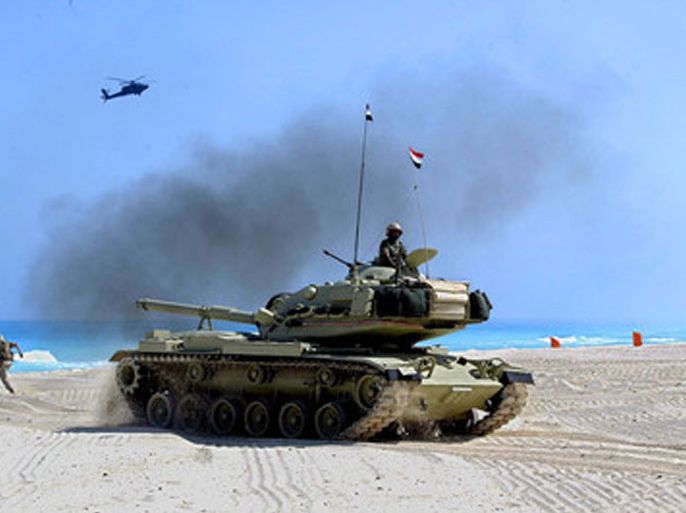 A US Marine runs as a US attack helicopter flies over an Eygptian tank during a Bright Star military amphibious beach assault on the Mediterranean coast of Egypt Thursday 15 September 2005. A number of countries from Europe and the Arab world are participating in the joint United States and Egyptian military exercises for the Maritime Security Operations which are held every four years and last a month. EPA/MIKE NELSON