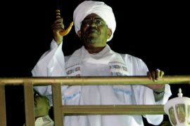 Sudanese President Omar al-Bashir greets anti-Israeli demonstrators in Khartoum on October 24, 2012, after the Sudanese cabinet held an urgent meeting regarding the missile strike that hit a military factory. Sudan has accused Israel of the attack and has threatened to take action