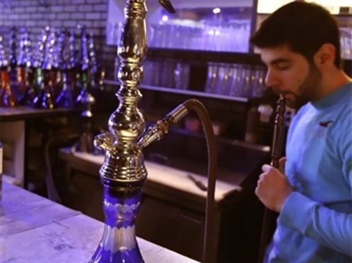 Hamze Nasser, assistant manager of 360, a Dearborn, Mich. , restaurant, starts a hookah for a customer, Friday, April 9, 2010. Come May 1 a new state law will ban the hookhas from Dearborn eateries. Cafes will have to choose between serving food and liquor or allowing smoking. Hookahs will be welcome only in specialty tobacco stores.