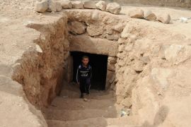 طفل يخرج من مغارة حفرتها عائلته بجانب بيته للاحتماء بها من القصف1