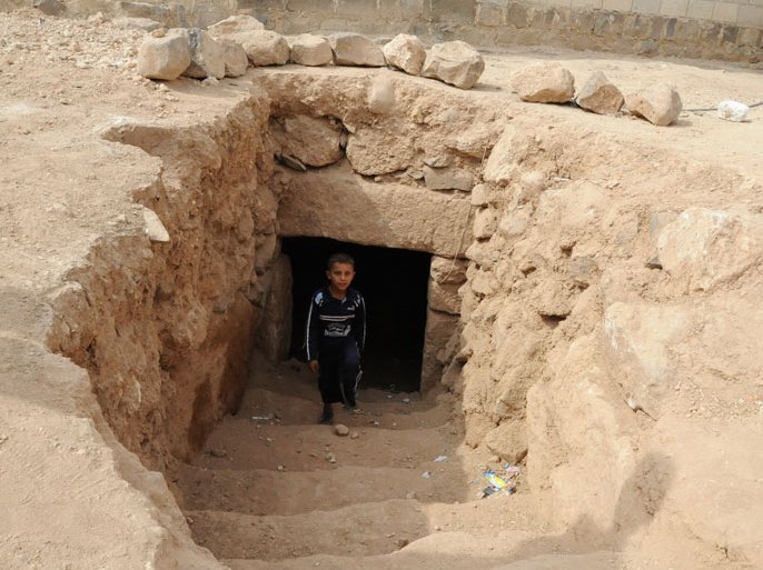 طفل يخرج من مغارة حفرتها عائلته بجانب بيته للاحتماء بها من القصف1