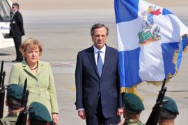 ARIS344 - Athens, -, GREECE : Greek Prime Minister Antonis Samaras (R) welcomes German Chancellor Angela Merkel (L) on October 9, 2012 at the airport in Athens. Merkel is on her first visit to Greece since the debt crisis erupted almost three years ago, as protesters geared up for a major show of discontent against painful austerity cuts. AFP