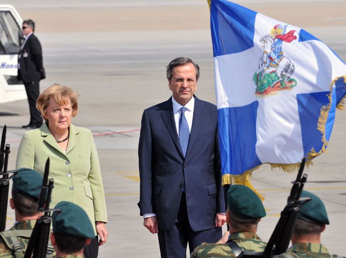 ARIS344 - Athens, -, GREECE : Greek Prime Minister Antonis Samaras (R) welcomes German Chancellor Angela Merkel (L) on October 9, 2012 at the airport in Athens. Merkel is on her first visit to Greece since the debt crisis erupted almost three years ago, as protesters geared up for a major show of discontent against painful austerity cuts. AFP