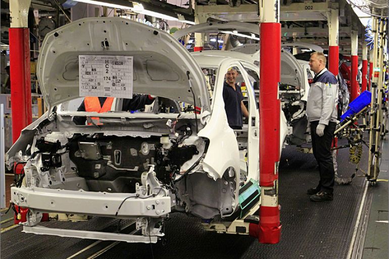 Employees assemble a Toyota Yaris Hybrid cars on the assembly line at the Toyota car assembly plant in Onnaing, northern France, October 8, 2012. REUTERS/Pascal Rossignol (FRANCE - Tags: TRANSPORT BUSINESS EMPLOYMENT)