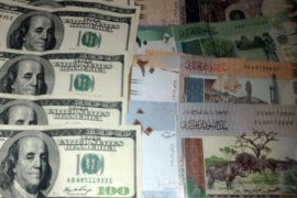 عملة سودانية ودولار أميركي - تباين حول هبوط الجنيه مقابل الدولار الأميركي - عماد عبد الهادي الخرطوم