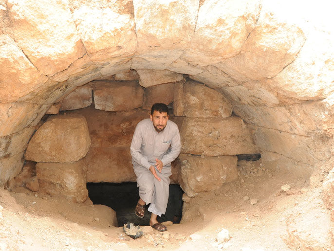 ‪أبو هاشم يخرج من مغارة هي عبارة عن قبر روماني قديم اضطر الاهالي لحفره للاختباء فيه‬ (الجزيرة)
