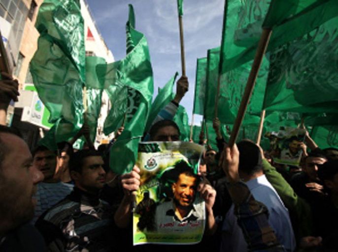 1367 - RAMALLAH, WEST BANK, - : Palestinian protestors hold up the Hamas Islamist movement flag and a portrait of assassinated Hamas leader Ahmed Jaabari during a rally in the West Bank city of Ramallah on November 16, 2012 . Thousands of angry Palestinians rallied across the West Bank, urging Hamas militants to "bomb Tel Aviv" as Israel pursued a relentless air campaign on the Gaza Strip. AFP PHOTO / ABBAS MOMANI