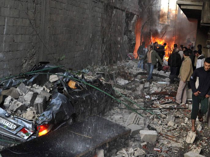 SYRIA : Syrian men inspect the scene of a car bomb explosion in Jaramana, a mainly Christian and Druze suburb of Damascus, on November 28, 2012. At least two car bombs exploded in Damascus killing and injureing a numbe of people