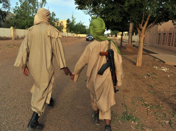 MALI : (FILES) Two young fighters of the Islamist group Movement for Oneness and Jihad in West Africa (MUJAO) walk in the streets of Gao on July 17, 2012. A West African military force assembled to intervene against Islamic radicals in Mali is ready to be deployed as soon as the United Nations issues a green light, a senior official at the centre of the preparations claimed on November 13, 2012. AFP PHOTO / ISSOUF SANOGO