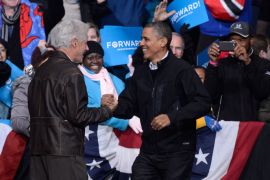 epa03457200 Former US President Bill Clinton (L) greets US President Barack Obama at a campaign rally in Bristow, Virginia, USA 03 November 2012. President Obama caps off a day of campaigning with a late night stop with President Clinton. EPA/SHAWN THEW