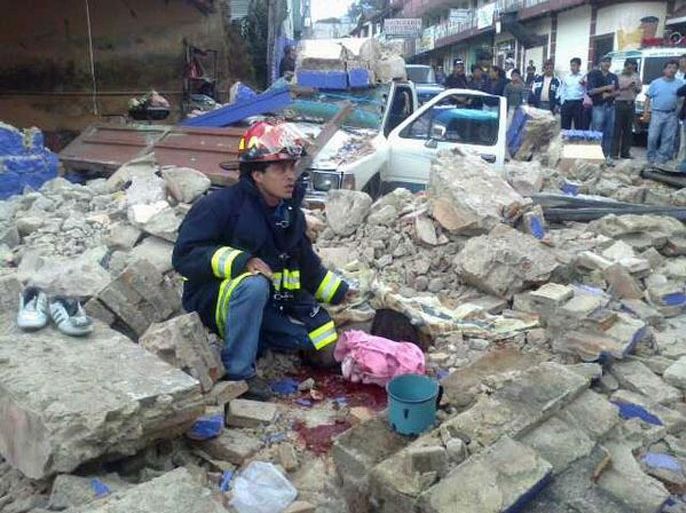 Handout picture of a firefighters staying next to a body found under the ruins of a collapsed house in San Marcos, 240 km from Guatemala City,on November 7, 2012. At least 10 people died in southwestern Guatemala after a strong 7.4-magnitude earthquake struck off the country's Pacific coast on Wednesday, a firefighters' spokesman told AFP. AFP PHOTO/BOMBEROS DE GUATEMALA RESTRICTED TO EDITORIAL USE-NO MARKETING-NO ADVERTISING CAMPAIGNS-MANDATORY CREDIT 'AFP PHOTO/BOMBEROS DE GUATEMALA' -DISTRIBUTED AS A SERVICE TO CLIENTS