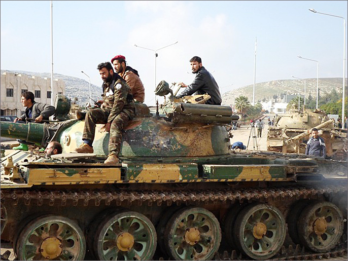 ‪عناصر الجيش الحر يعتلون دبابة للجيش النظاني سيطروا عليها في وقت سابق‬ (الجزيرة)