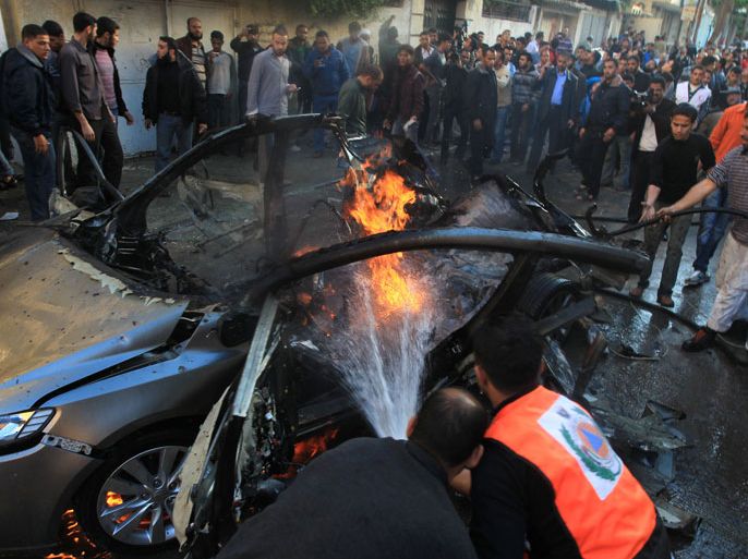 GAZA CITY, GAZA STRIP, - : Palestinian firefighters extinguish fire from the car of Ahmaed Jaabari, head of the military wing of the Hamas movement, the Ezzedin Qassam Brigades, after it was hit by an Israeli air strike in Gaza City on November 14, 2012. The top Hamas commander Ahmed al-Jaabari was killed in an Israeli air strike , medics and a Hamas source told . AFP PHOTO/MAHMUD HAMS