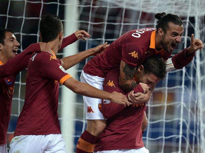 AS Roma forward Francesco Totti (R) celebrates with teammates after scoring against Palermo on November 4, 2012 during a Serie A football match at the Olympic Stadium in Rome. AFP PHOTO / FILIPPO MONTEFORTE