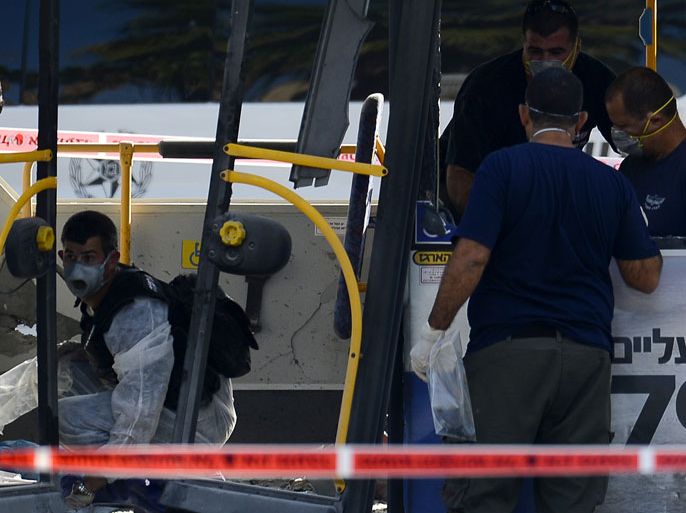 Tel Aviv, -, ISRAEL : Israeli forensic experts inspect a bus which was hit by a bomb near the defence ministry in Tel Aviv on November 21, 2012. At least 10 people were injured in an explosion on a bus, Israel's emergency services said, in what an official said was "a terrorist attack." AFP PHOTO / JONATHAN NACKSTRAND