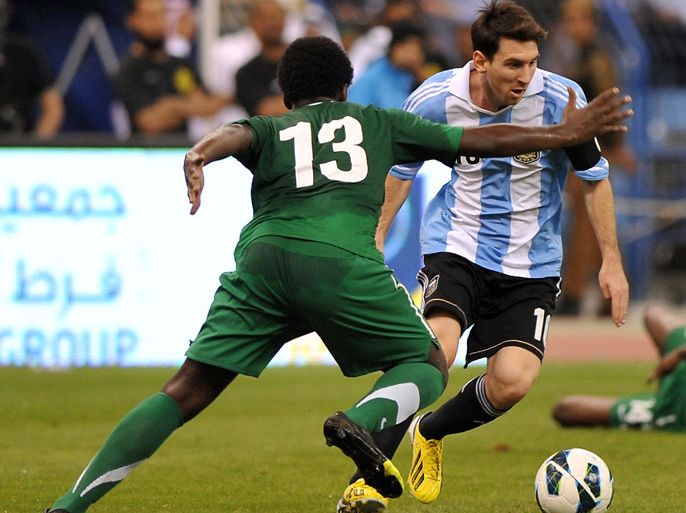 Saudi Arabia's Motaz al-Musa (L) challenges Argentina's forward Lionel Messi during their friendly football match at King Fahd stadium in the Saudi capital Riyadh on November 14, 2012. The match ended in a goalless draw. AFP PHOTO/FAYEZ NURELDINE