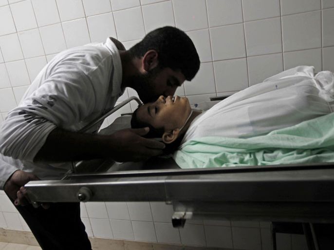 KHAN YUNIS, GAZA STRIP, - : A Palestinian relative of Hmeid Abu Daqqa, 13, bids him farewell at the morgue of a hospital in Khan Yunis, in the southern Gaza Strip on November 8, 2012. Daqqa died after being hit by bullets fired from an Israeli helicopter in the Gaza Strip, a medical official told AFP. AFP PHOTO/ SAID