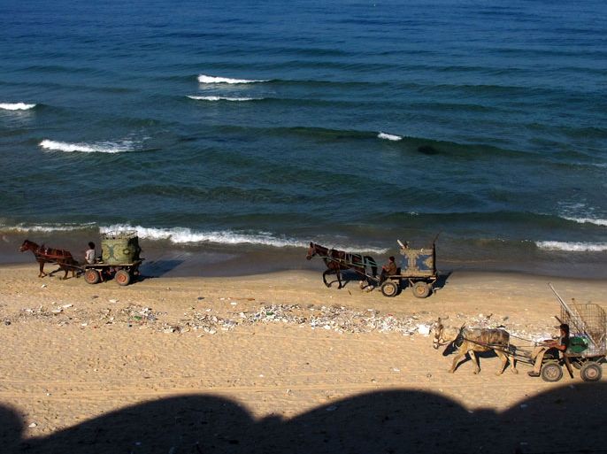 Palestinian scrap collectors ride their donkey karts on a beach in Gaza City on November 28, 2012. UN chief Ban Ki-moon called for renewed efforts to achieve a two-state solution in the Middle East following last week's ceasefire between Israel and Hamas. AFP PHOTO / PATRICK BAZ