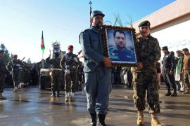 Herat, -, AFGHANISTAN : Afghan security personnel march with a portrait of slain Nimroz province police chief Musa Rasouli during a funeral procession in Herat on December 11, 2012. A Taliban roadside bomb killed the top police commander of a western Afghan province on December 10, officials said. The police chief of the remote province of Nimroz, Musa Rasouli, was driving to work from the neighbouring province of Herat when his vehicle was hit by the bomb, the Herat governor's spokesman said. AFP PHOTO/ AREF KARIMI
