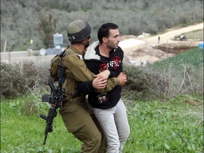 A Palestinian resident of the northern West Bank village of Madama is detained by an Israeli soldier as security forces came to intervene in clashes between Palestinian farmers and Israeli settlers from the Yitzhar settlement, on December 17, 2012 in the Israeli-occupied West Bank, near Nablus. AFP PHOTO/JAAFAR ASHTIYEH