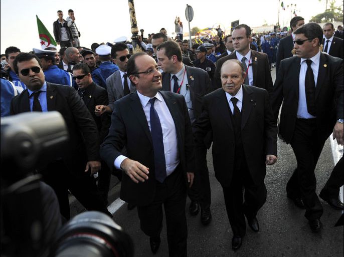 French President Francois Hollande (L) and his Algerian counterpart Abdelaziz Bouteflika (R) greet the crowd during a tour of Algiers on December 19, 2012. Hollande arrived in Algeria for a landmark visit to the former French territory, amid hopes of a new phase in relations but persistent bitterness over crimes committed during colonial rule. AFP PHOTO/FAROUK BATICHE