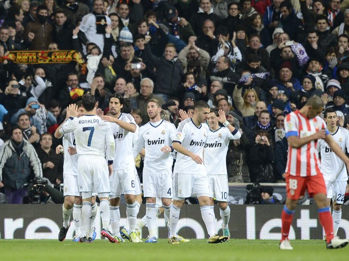 Real Madrid's players celebrate after their teammate German midfielder Mesut Ozil scored during the Spanish league football match Real Madrid CF vs Atletico Madrid at the Santiago Bernabeu stadium in Madrid on December 1, 2012. AFP PHOTO / PIERRE-PHILIPPE MARCOU