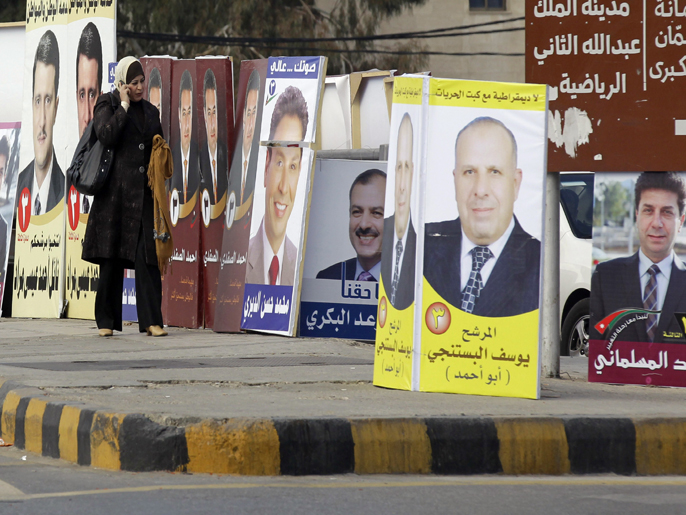 AMM02 - Amman, -, JORDAN : A Jordanian woman walks past pictures of parliament candidates in Amman on December 29, 2012. Jordan's electoral authority set January 23 as the date for a general election after King Abdullah II dissolved parliament despite a boycott pledge by the opposition Muslim Brotherhood. AFP PHOTO/KHALIL MAZRAAWI