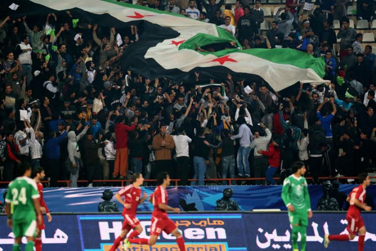 Syrian football fans wave a giant pre-Baath Syrian flag during Syria's final football match against Iraq in the 7th West Asia Football Federation (WAFF) championship in Kuwait City , on December 20, 2012. Syria won 1-0. AFP PHOTO/MARWAN NAAMANI