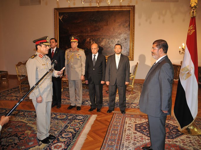 This handout picture made available by the Egyptian presidency show President Mohammed Morsi (R) swearing in Egypt's new minister of defence, Abdel Fattah al-Sissi (L), at the presidential palace in Cairo on August 12, 2012. Egypt's Islamist president also ordered the surprise retirement of his powerful defence minister and scrapped a constitutional document which handed sweeping powers to the military. AFP PHOTO/HO/EGYPTIAN PRESIDENCY == RESTRICTED TO EDITORIAL USE - MANDATORY CREDIT "AFP PHOTO/EGYPTIAN PRESIDENCY" - NO MARKETING NO ADVERTISING CAMPAIGNS - DISTRIBUTED AS A SERVICE