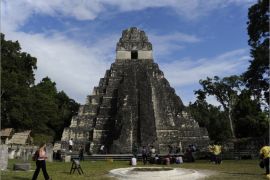 Tourists are seen in front of the "Gran Jaguar" Mayan temple at the Tikal archaeological site in Peten departament, 560 kms north of Guatemala City, on December 19, 2012. Ceremonies will be held here to celebrate the end of the Mayan cycle known as Bak'tun 13 and the start of the new Maya Era on December 21. AFP PHOTO/Johan ORDONEZ