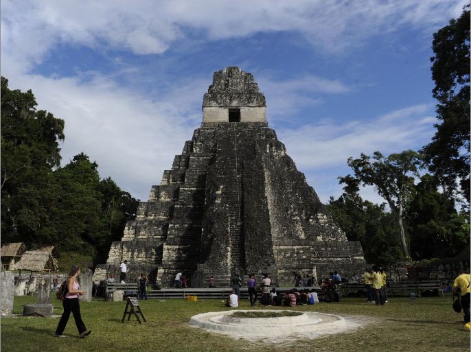 Tourists are seen in front of the "Gran Jaguar" Mayan temple at the Tikal archaeological site in Peten departament, 560 kms north of Guatemala City, on December 19, 2012. Ceremonies will be held here to celebrate the end of the Mayan cycle known as Bak'tun 13 and the start of the new Maya Era on December 21. AFP PHOTO/Johan ORDONEZ