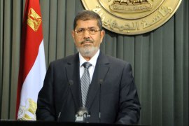 A hand out picture released by Egyptian Presidency shows Egyptian President Mohamed Morsi giving a televised speech on December 26, 2012, after signing into law a contentious constitution he and Islamist allies backed to the fury of the opposition and to international concern. Morsi said he would shuffle his government to tackle pressing economic problems, in his national address during which he hailed a new constitution backed by his Islamist allies. AFP PHOTO/HO/EGYPTIAN PRESIDENCY == RESTRICTED TO EDITORIAL USE - MANDATORY CREDIT "AFP PHOTO / HO / EGYPTIAN PRESIDENCY" - NO MARKETING NO ADVERTISING CAMPAIGNS - DISTRIBUTED AS A SERVICE TO CLIENTS ==