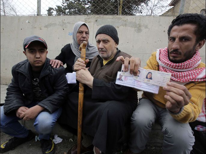 Palestinians who fled violence in the refugees camp of Yarmuk are seen at the Masnaa Lebanese border crossing with Syria as people stamp their documents before entering Lebanon on December 19, 2012. A large number of Palestinians refugees and others who fled the Damascus suburb of Yarmuk and the Yarmuk refugee camp arrived at the border crossing fleeing the fighting in and around their district. According to the United Nations agency for Palestinian refugees the population of the refugee camp has halved as Syrian rebels made advances in a fierce battle for control of the camp in southern Damascus the Syrian Observatory for Human Rights said. AFP PHOTO /JOSEPH EID