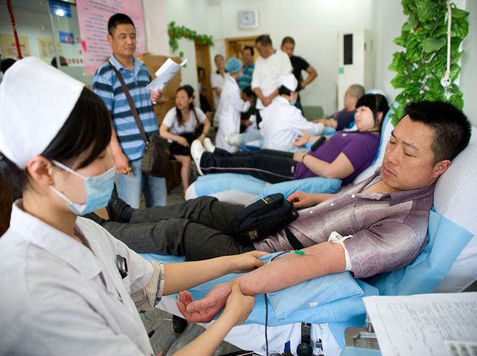epa02779306 A Chinese man donates blood at a blood-donation station on the 8th World Blood Donor Day in the city of Qingdao, eastern China's Shandong province, 14 June 2011. The theme for World Blood Donor Day 2011 is, 'More blood. More life.' The theme reinforces the urgent need for more people all over