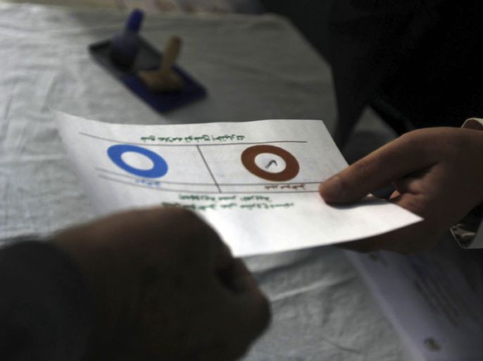 r : A man marks "disagree" on his ballot while voting during a referendum on the new Egyptian constitution, at a polling station in Cairo December 15, 2012. Egyptians voted on Saturday on a constitution promoted by its Islamist backers as the way out of a prolonged political crisis and rejected by opponents as a recipe for further divisions in the Arab world's biggest nation. REUTERS/Amr Abdallah Dalsh  (EGYPT - Tags: POLITICS ELECTIONS)