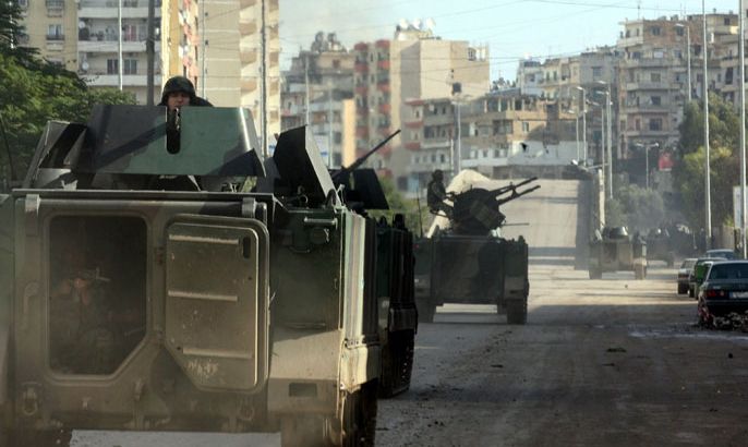 Lebanese soldiers ride in their armoured vehicle as they patrol the streets of the northern Lebanese city of Tripoli on December 5, 2012, the day after snipers shot dead two men as sectarian clashes linked to the conflict in neighbouring Syria broke out, a security official said