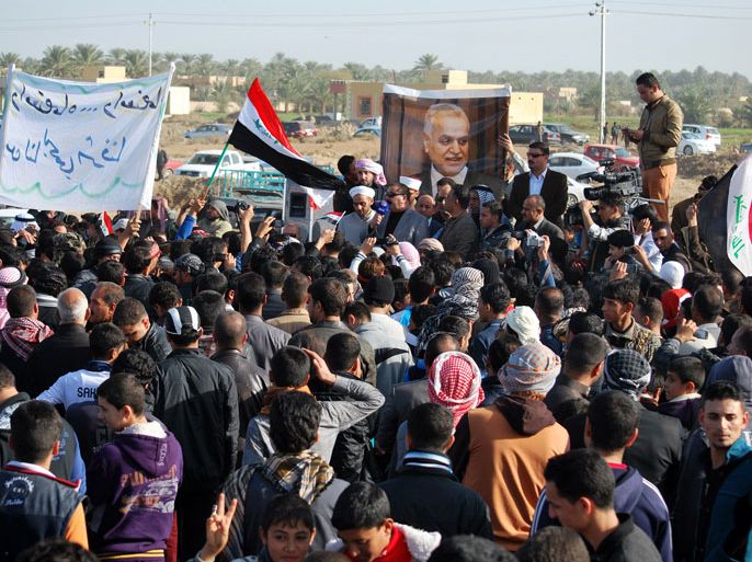 RAM96 - Ramadi, -, IRAQ : Iraqi protesters, demanding the ouster of premier Nuri al-Maliki, block on December 23, 2012 a highway in western Iraq leading to Syria and Jordan, in Ramadi. The protesters, including local officials, religious and tribal leaders, turned out in Ramadi, the capital of Sunni province of Anbar, to demonstrate against the arrest of nine guards of Finance Minister Rafa al-Essawi. The poster shows former Iraqi vice president Tariq al-Hashemi. AFP PHOTO/STR