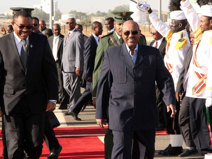 Ethiopian Prime Minster Hailemariam Desalegn (L) walks alongside Sudanese President Omar al-Bashir (R) as they review an honor guard upon the first's arrival in the Sudanese capital Khartoum on December 26, 2012. Desalegn is on an official visit to Khartoum to bolster peace efforts between Sudan and South Sudan, official media said. AFP PHOTO/EBRAHIM HAMID