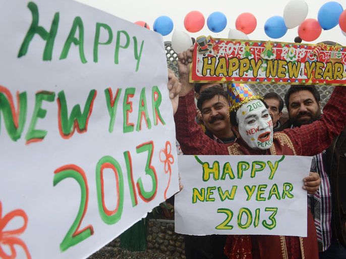 INDIA : Indian revellers hold placards in Amritsar on December 31, 2012. Sydney will kick off a wave of dazzling firework displays welcoming in 2013, from Dubai to Moscow and London, with long-isolated Yangon joining the